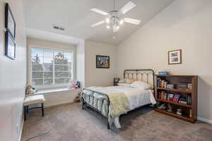 Carpeted bedroom featuring lofted ceiling, baseboards, and ceiling fan