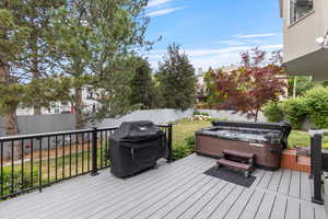 Wooden deck featuring a hot tub and area for grilling