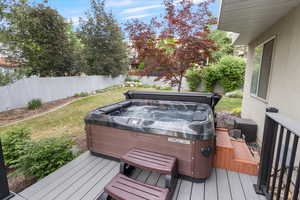 Deck featuring a hot tub and a fenced backyard