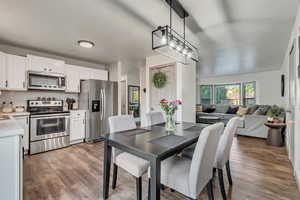 Dining space with views of a kitchen, a pantry in the central "pillar," and of a living room