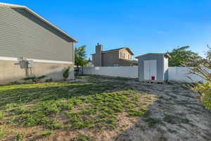 View of fenced backyard with a shed