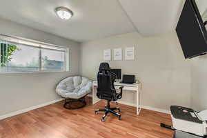 Bedroom used as a home office featuring contemporary laminate flooring and baseboards