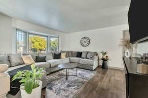 Living room featuring bay windows, contemporary laminate flooring, and baseboards