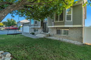 Bi-level home featuring brick siding, driveway, and a garage