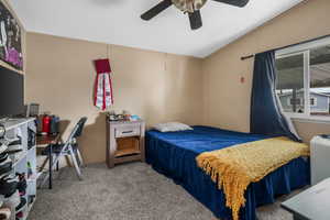 Carpeted bedroom with a ceiling fan