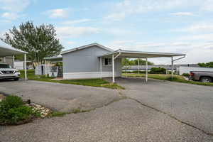 View of property exterior with driveway and an attached carport