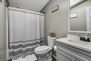 Bathroom featuring toilet, vanity, and shower / bath combo