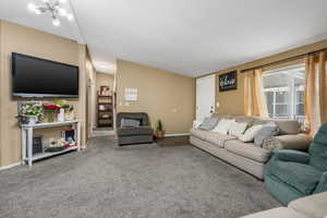 Living room with lofted ceiling, carpet, and baseboards