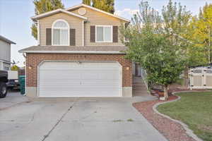 View of front of home with brick siding, a garage, concrete driveway, and a shingled roof