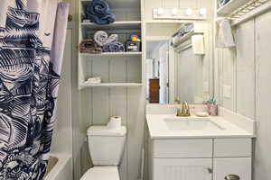 Bathroom with vanity, toilet, and shower / bath combo