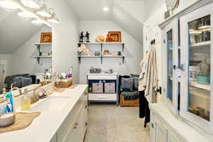 Bathroom featuring vaulted ceiling and vanity