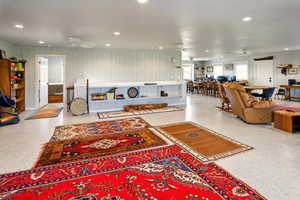Living area with ceiling fan, recessed lighting, and speckle patterned floor