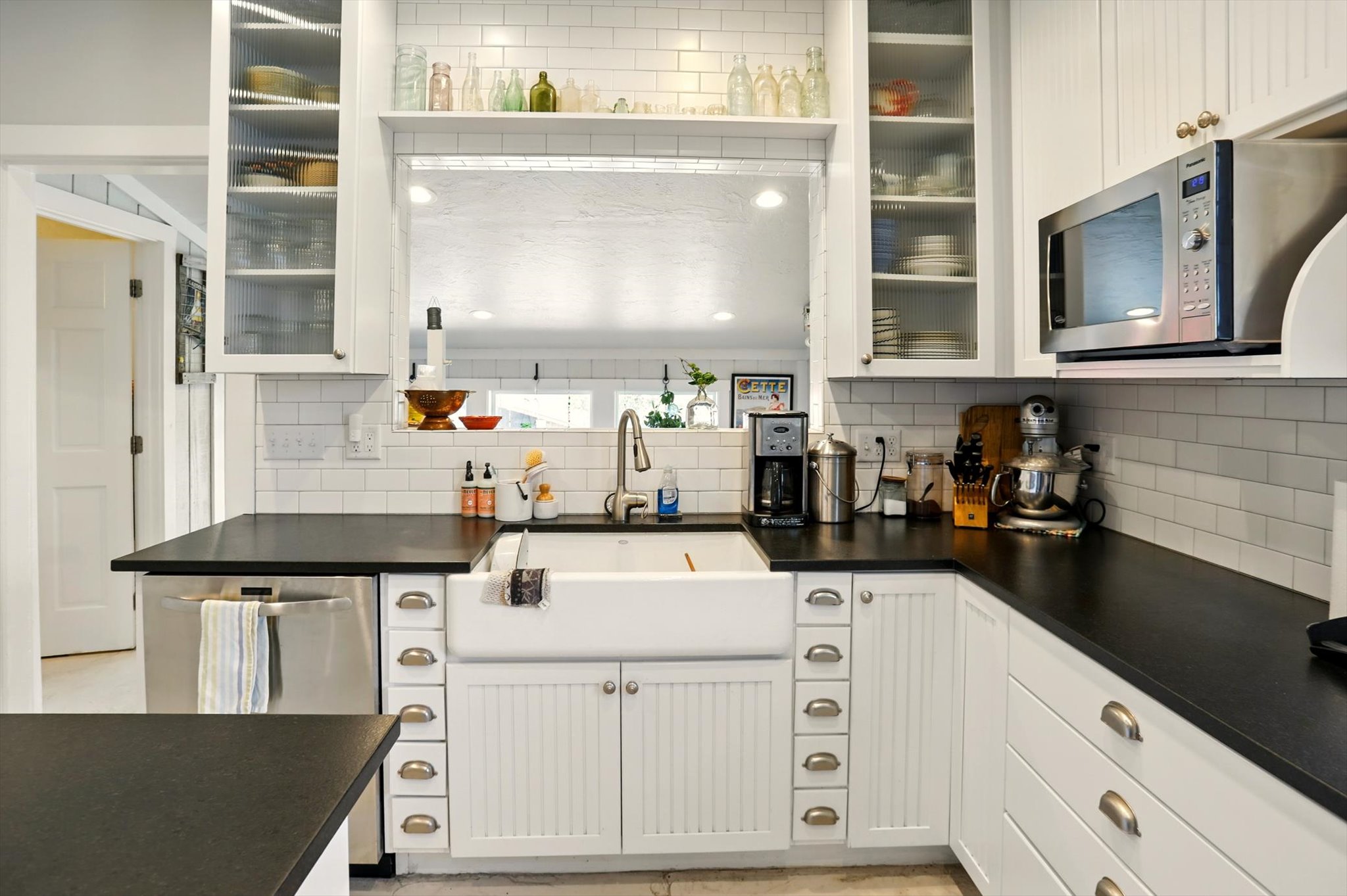 Kitchen with stainless steel appliances, a sink, tasteful backsplash, and dark countertops