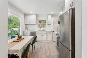 Newly renovated kitchen with stainless steel appliances, quartz countertops, and large window