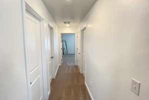 Hall with dark carpet and baseboards