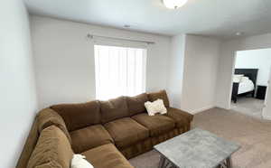 Carpeted living area featuring baseboards