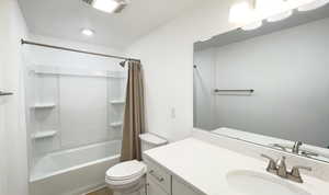 Full bath with vanity, shower / bath combo, and toilet