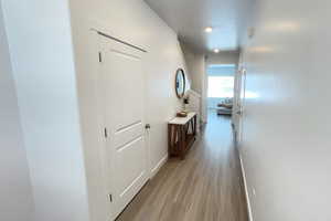 Corridor featuring light wood-style flooring and baseboards