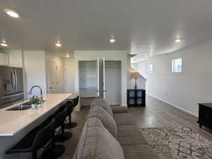 Living area featuring an office area, dark wood-style floors, recessed lighting, baseboards, and a textured ceiling