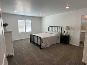 Bedroom with dark carpet, baseboards, recessed lighting, and a textured ceiling