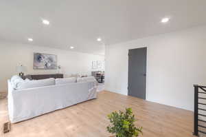 Living area featuring light wood-type flooring, recessed lighting, and baseboards