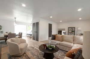 Living area with light wood finished floors, recessed lighting, and baseboards