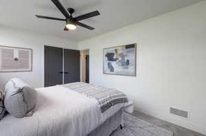 Bedroom with light carpet, baseboards, and a ceiling fan
