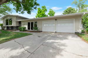 Split level home with a garage, driveway, and a front yard