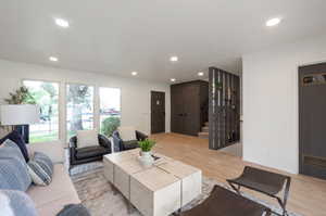 Living area with stairway, light wood-style flooring, and recessed lighting