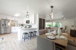 Dining room with light wood-style flooring, a chandelier, and recessed lighting