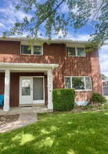 View of front of home featuring brick siding and a front lawn