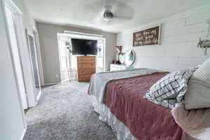 Cozy primary bedroom with shiplap accent wall and light.