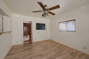 Unfurnished room featuring wood finished floors, a ceiling fan, and baseboards