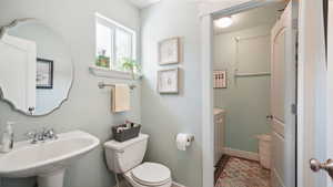 Bathroom with toilet, a sink, and baseboards