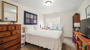Bedroom featuring dark colored carpet and baseboards