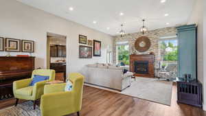 Living room featuring plenty of natural light, recessed lighting, wood finished floors, and a glass covered fireplace