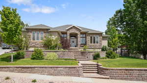 Prairie-style house featuring stucco siding, stone siding, and a shingled roof