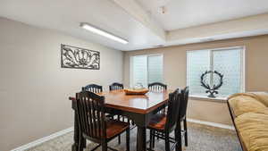 Carpeted dining room with baseboards