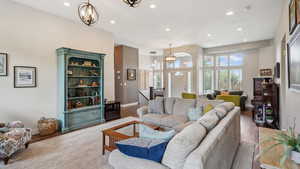 Living area with a chandelier, recessed lighting, baseboards, and wood finished floors