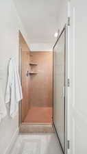 Full bathroom with a stall shower, tile patterned flooring, a textured ceiling, and baseboards