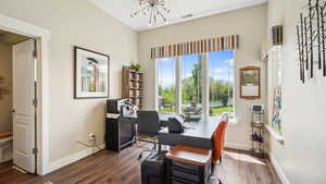 Home office with a chandelier, dark wood finished floors, and plenty of natural light