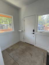 Foyer entrance with wood finished floors, plenty of natural light, and baseboards