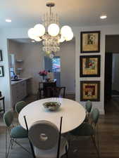 Dining space featuring wood finished floors, baseboards, a chandelier, and recessed lighting