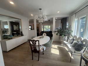 Dining space with a chandelier, light wood-style floors, and recessed lighting
