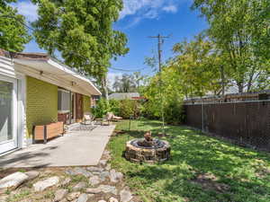View of backyard with a patio and a fire pit