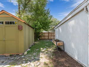 View of shed, back side of garage and apple tree