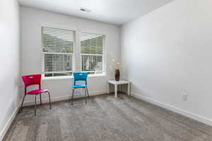 Sitting room featuring carpet floors and baseboards