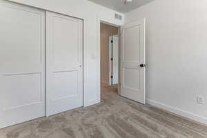 Unfurnished bedroom with carpet, a closet, and baseboards