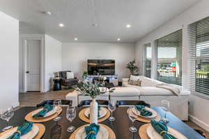 Living area with wood finished floors, baseboards, recessed lighting, and a textured ceiling