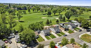 Aerial perspective of suburban area with a local golf course and a tree filled landscape